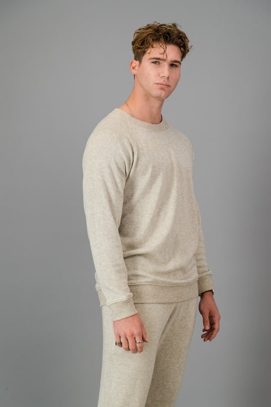 A man in Oatmeal Cashmere-Feel Crew Neck Sweater and matching joggers.