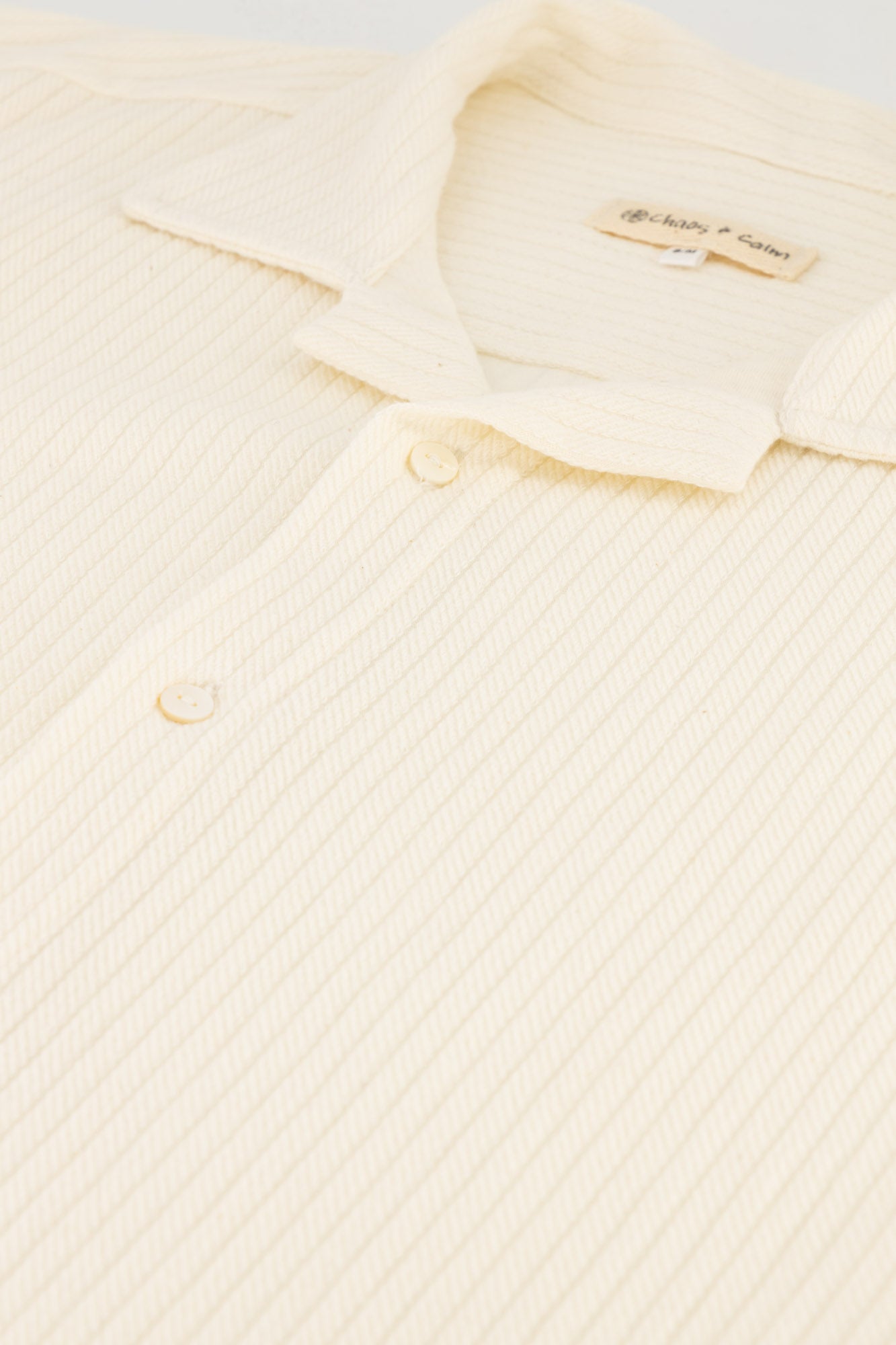 Flat-lay detail shot of a Braided Cable Cotton Fleece Shirt in cream.