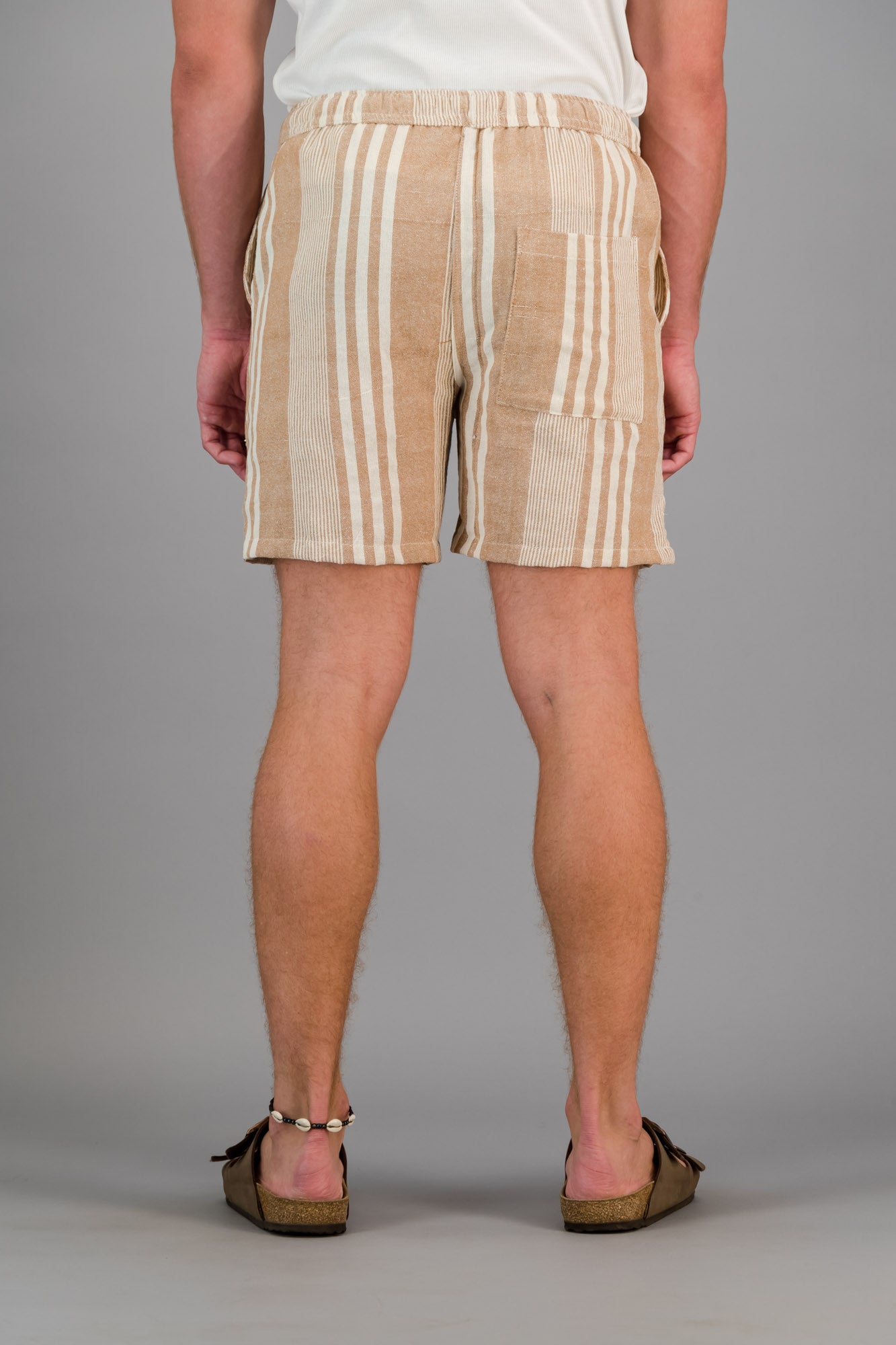 Model wearing brown striped cotton kikoi shorts.