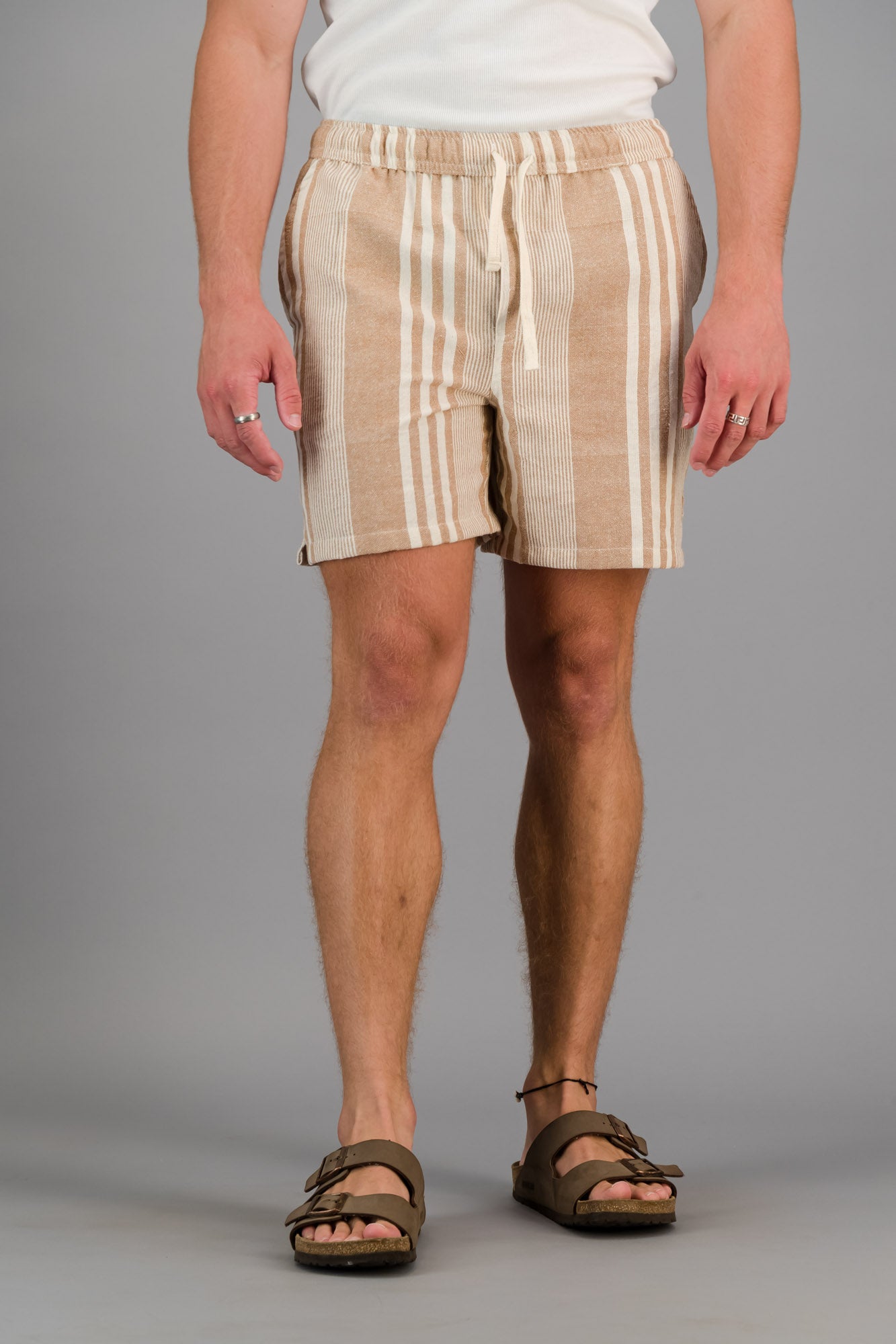 Model wearing brown striped cotton kikoi shorts.