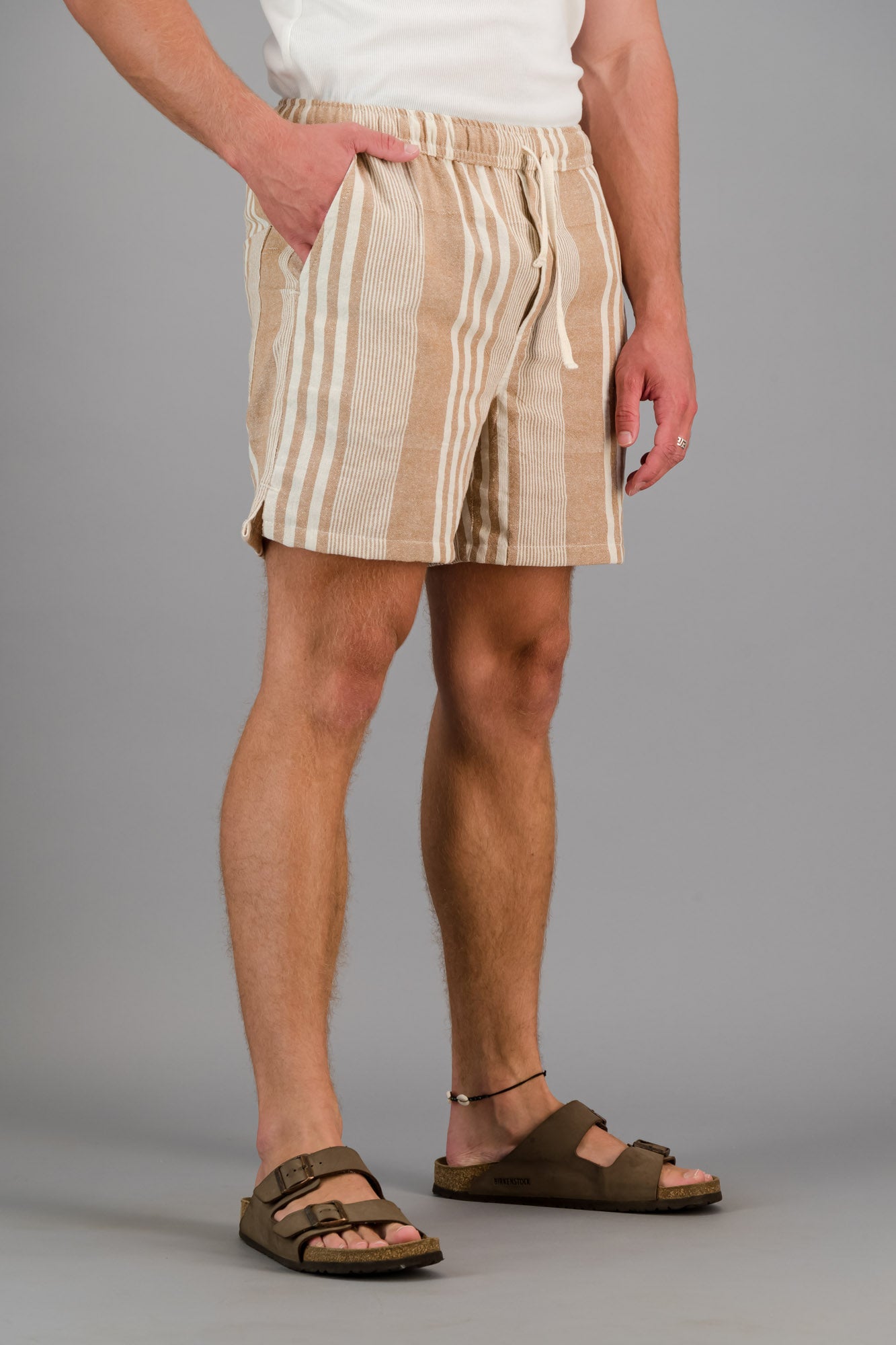 Model wearing brown striped cotton kikoi shorts.