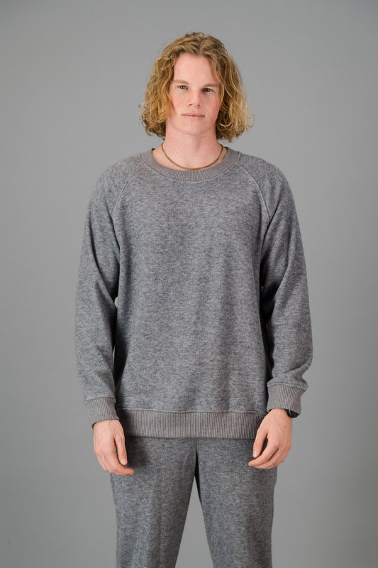 A man in a Grey Cashmere-Feel Crew Neck Sweater and matching joggers.