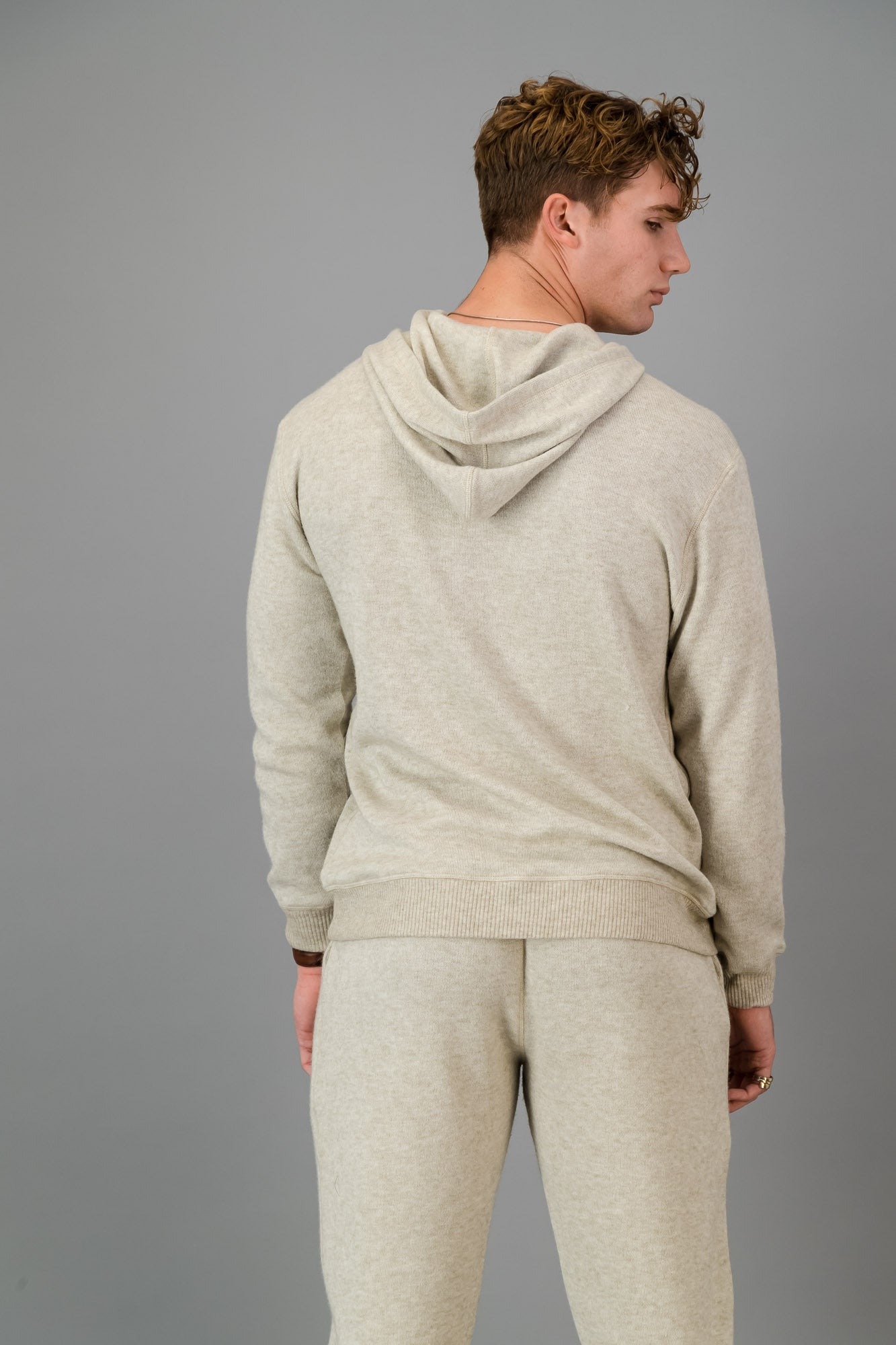 A man in an Oatmeal Cashmere-Feel Hoodie and matching joggers.