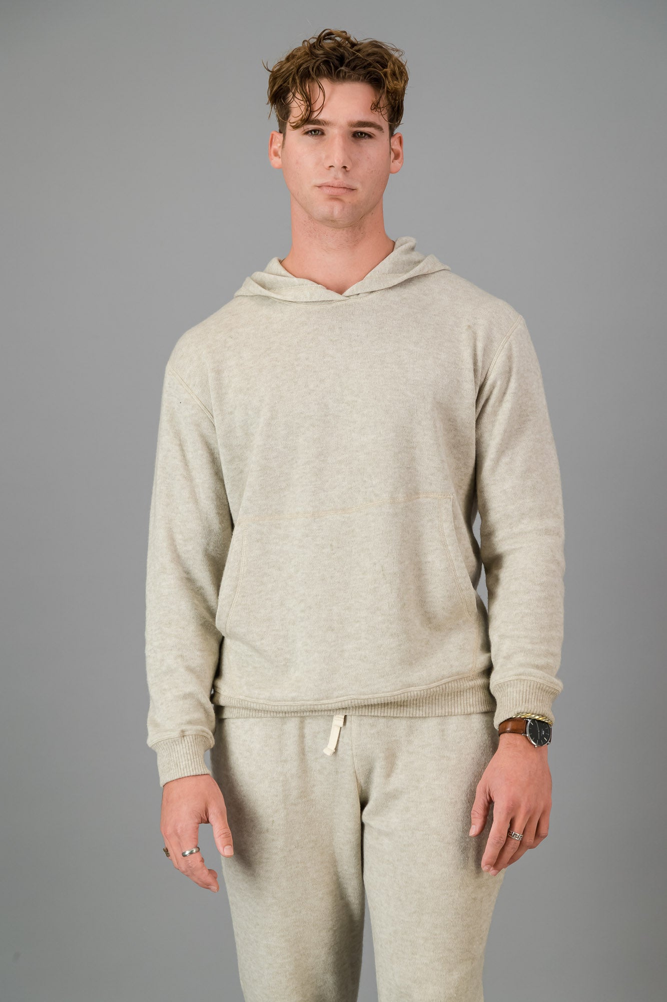 A man in an Oatmeal Cashmere-Feel Hoodie and matching joggers.