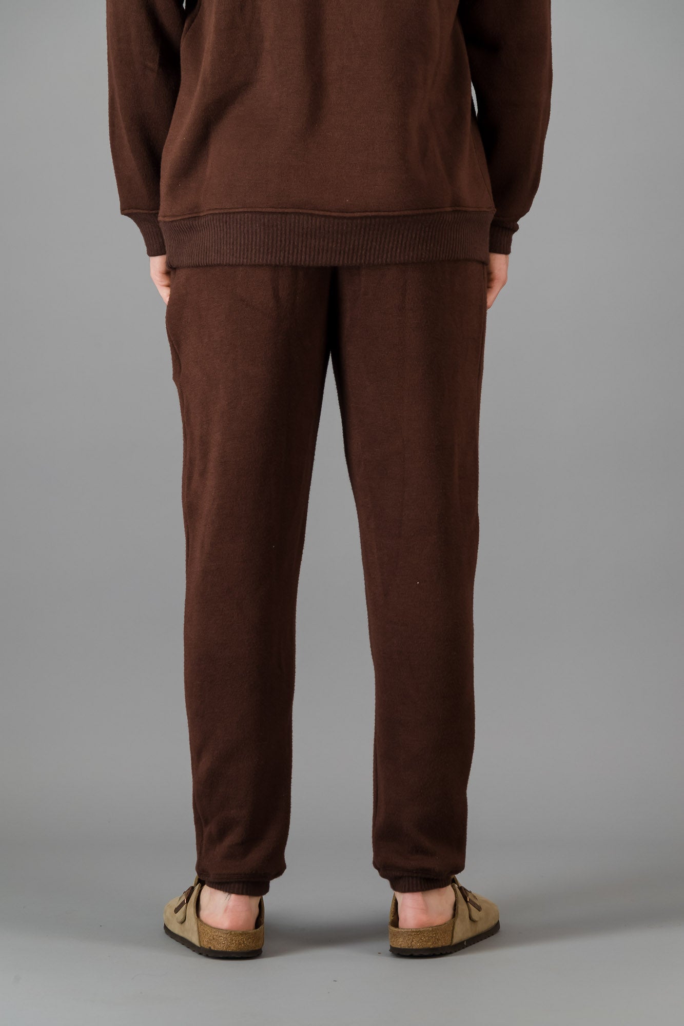 A man wearing Cashmere-Feel Knit Sweatpants in Chocolate with matching crew neck sweater.