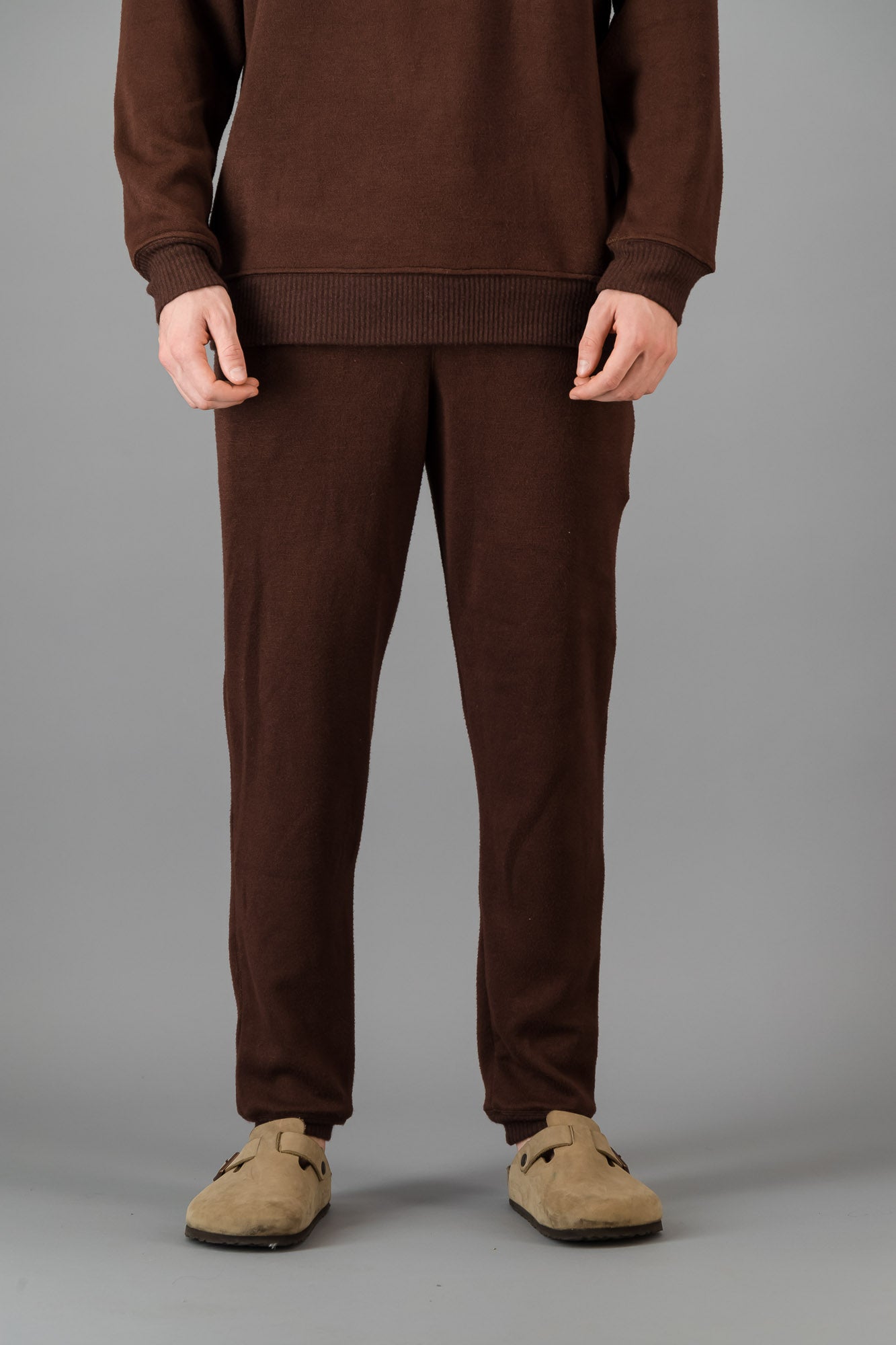 A man wearing Cashmere-Feel Knit Sweatpants in Chocolate with matching crew neck sweater.