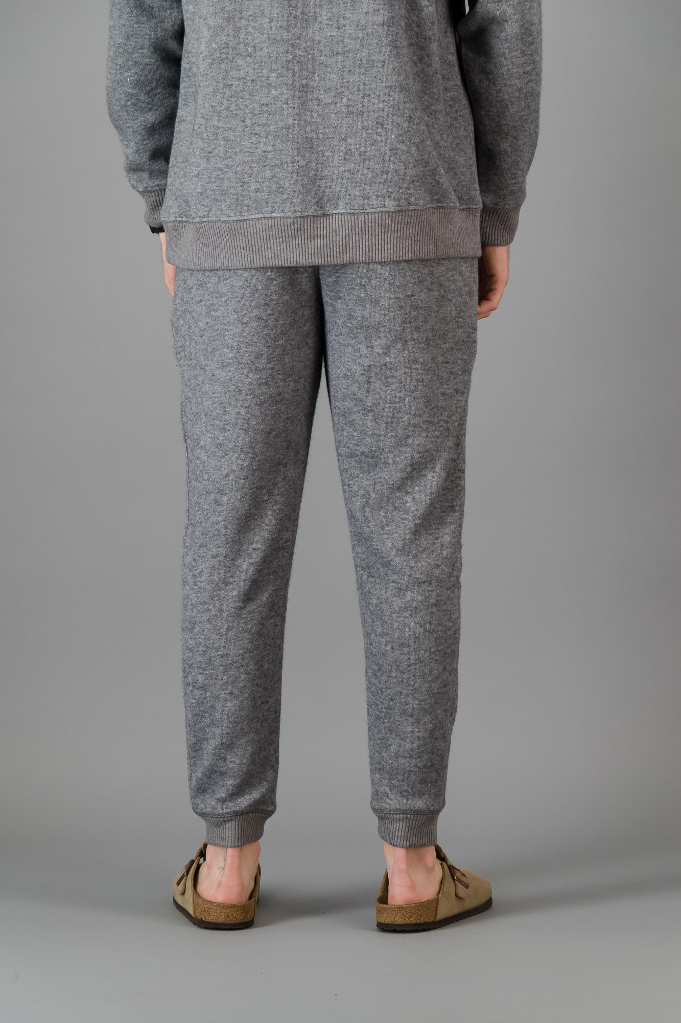 A man wearing Grey Cashmere-Feel Sweatpants with a matching crew neck sweater.