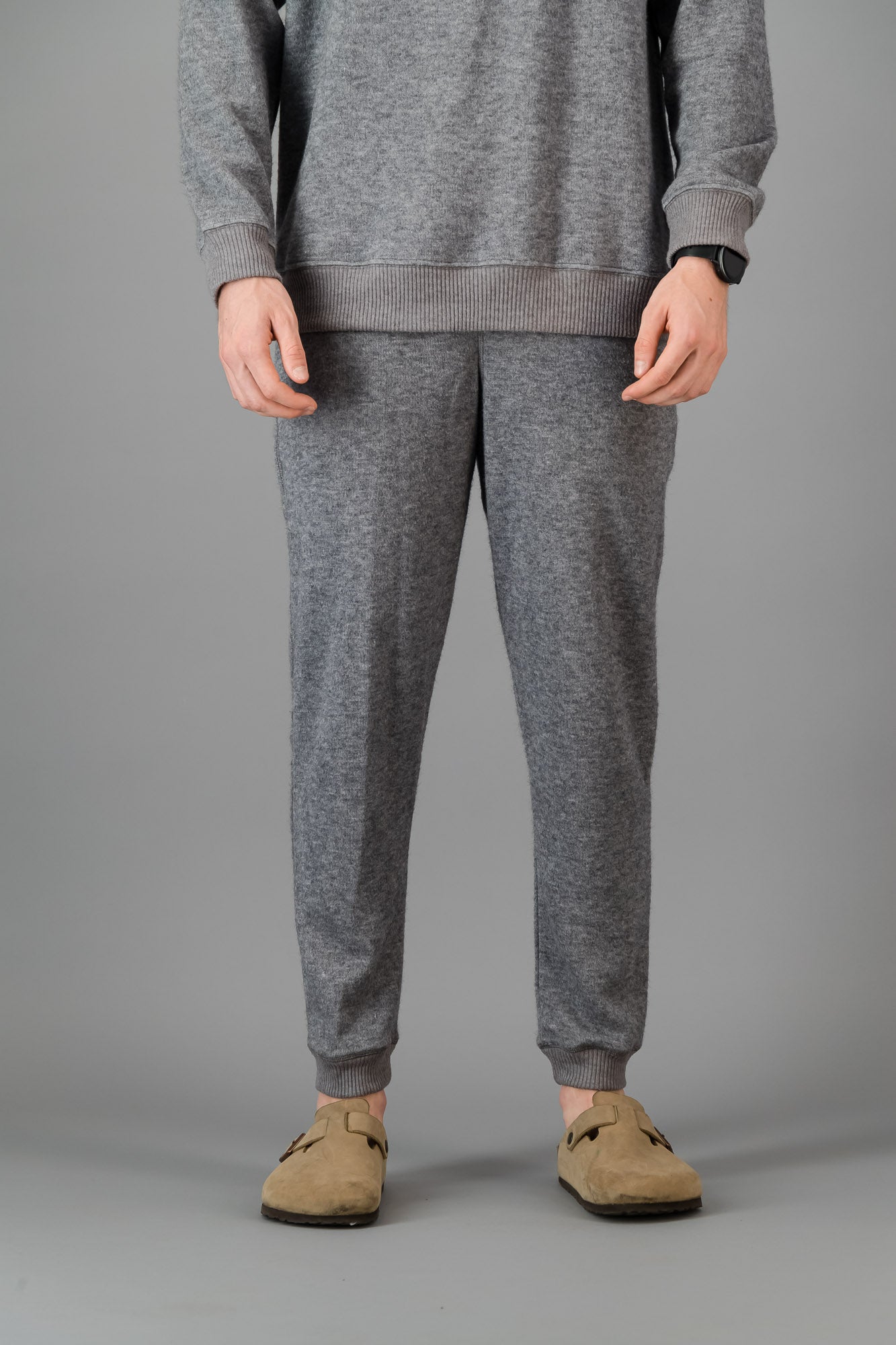 A man wearing Grey Cashmere-Feel Sweatpants with a matching crew neck sweater.