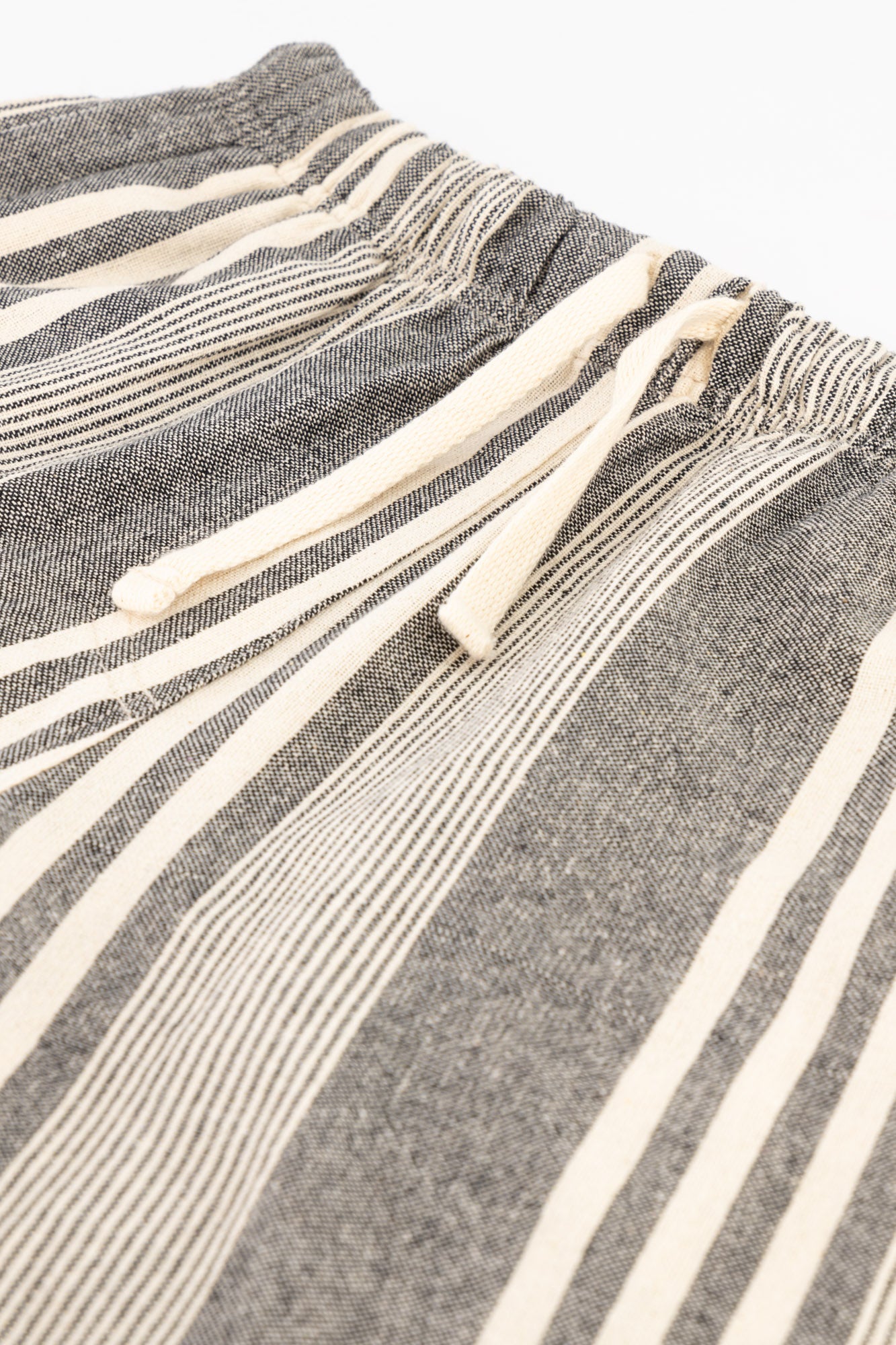 Flat-lay details shot of charcoal striped cotton kikoi shorts.