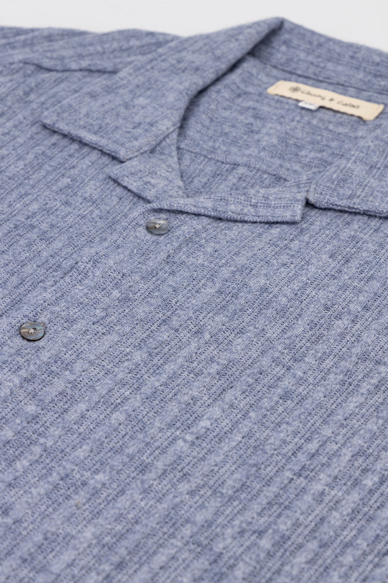 A flat-lay detail shot of a Rayon-rich Cable Knit Shirt in blue.