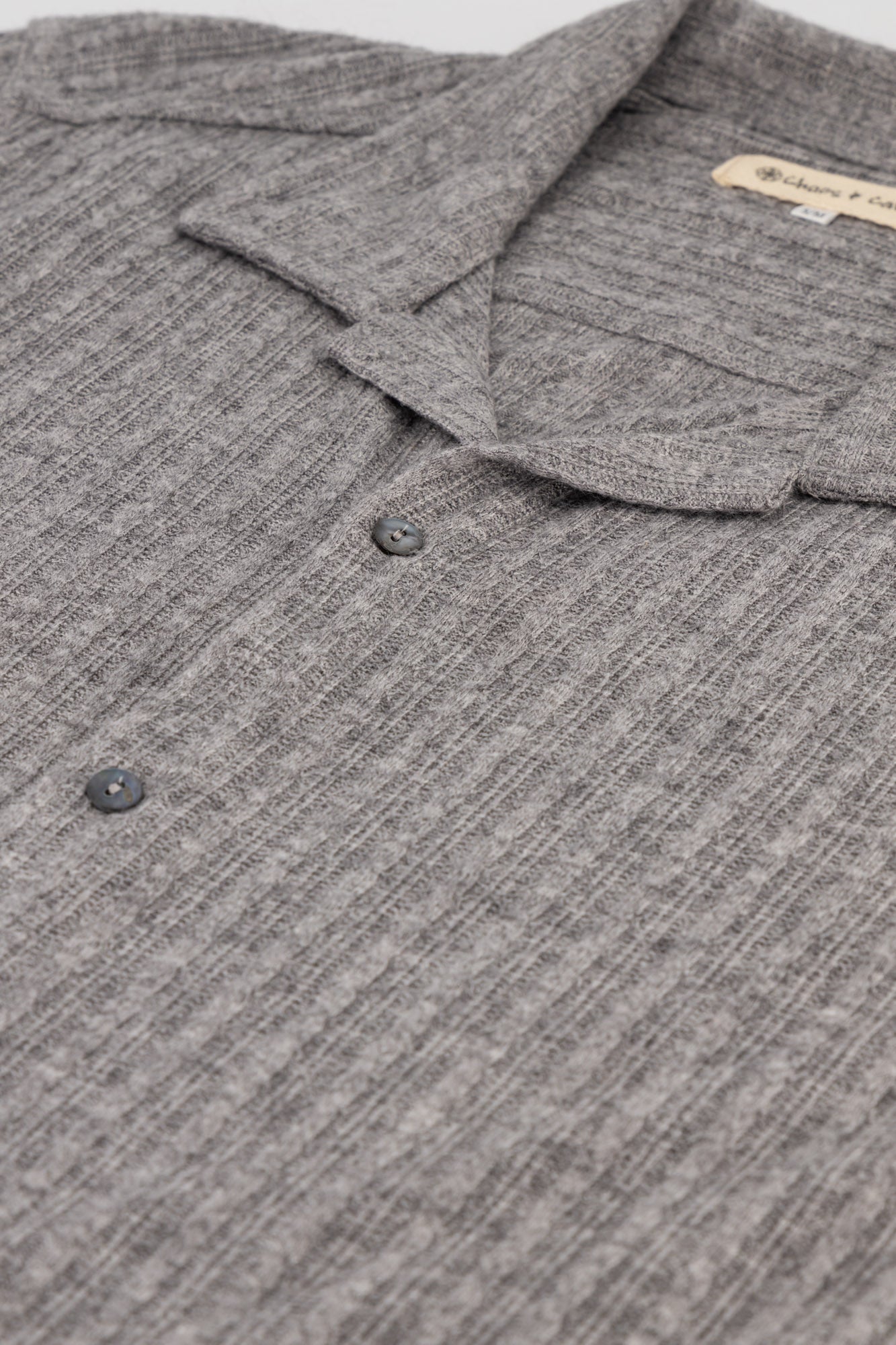 Flat-lay detail shot of a short-sleeve Rayon-rich Cable Knit Shirt in Grey.