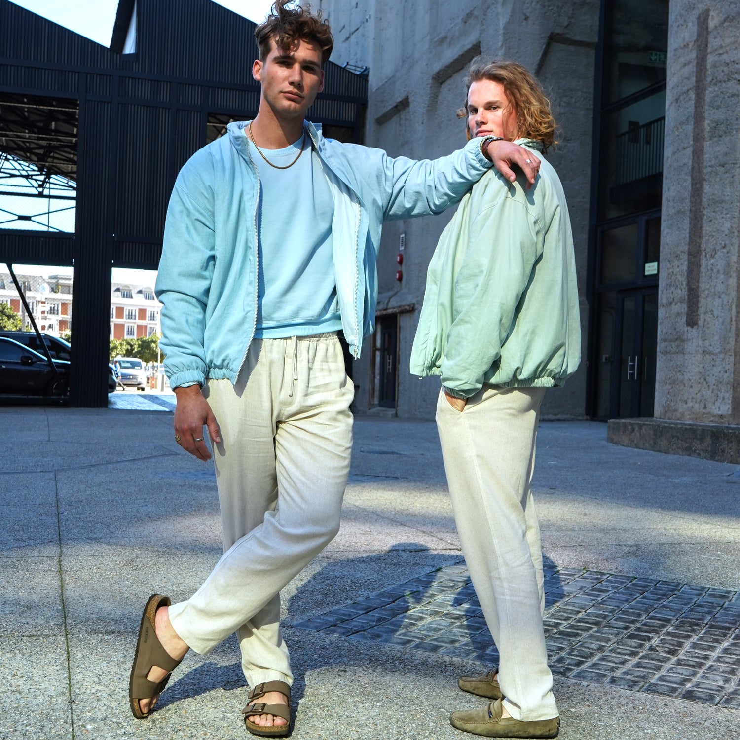 One model wearing our sky blue sweater and bomber with oatmeal linen pants and another model wearing our sage green sweater and bomber with oatmeal linen pants.